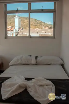 a bed in a room with a window at Hotel Plaza Centro Cocorná in Cocorná