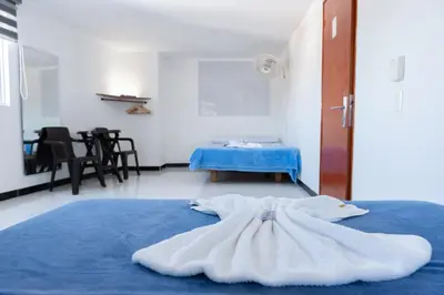 a blue bed with a dress laying on it at Hotel Plaza Centro Cocorná in Cocorná