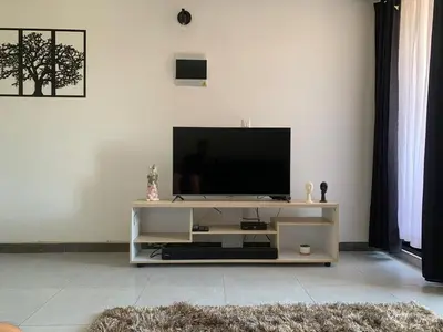 a living room with a television on a white entertainment center at Natural charm in Medellín in Medellín