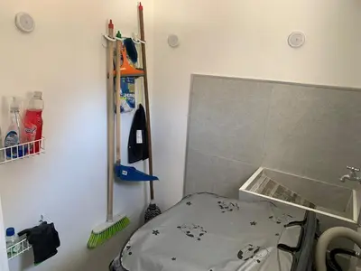 a corner of a room with a bed and a broom at Natural charm in Medellín in Medellín