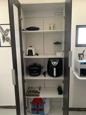 a kitchen pantry with white shelves and a appliance at Natural charm in Medellín in Medellín
