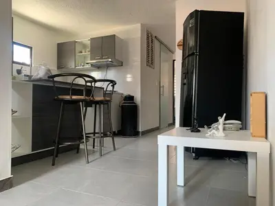 a kitchen with a white table and a black refrigerator at Natural charm in Medellín in Medellín
