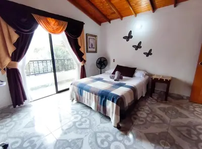 a bedroom with a bed and a large window at Acogedor apartamento cerca al tranvía 301 in Medellín