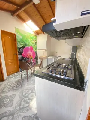 a kitchen with a stove and a dining room at Acogedor apartamento cerca al tranvía 301 in Medellín