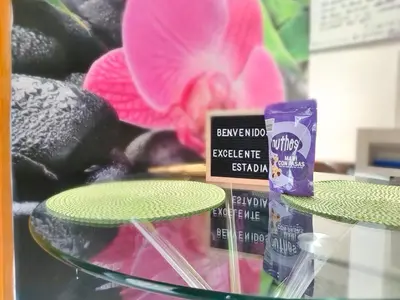 a glass table with two containers of toothpaste and a flower at Acogedor apartamento cerca al tranvía 301 in Medellín
