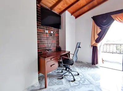 a desk and a chair in a room with a window at Acogedor apartamento cerca al tranvía 301 in Medellín