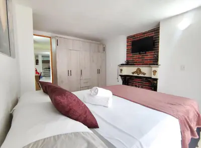 a bedroom with a bed and a fireplace at Acogedor apartamento cerca al tranvía 201 in Medellín