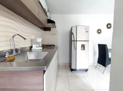 a kitchen with a sink and a refrigerator at Acogedor apartamento cerca al tranvía 201 in Medellín