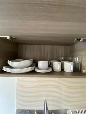 a shelf with plates and cups on it in a kitchen at Acogedor apartamento cerca al tranvía 201 in Medellín