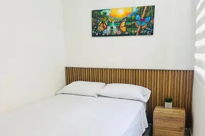 a bedroom with a bed and a picture on the wall at Apartaestudio San Diego Medellín in Medellín