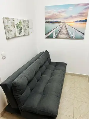 a couch in a room with a picture on the wall at Apartaestudio San Diego Medellín in Medellín