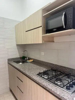 a kitchen with a stove and a microwave at Apartaestudio San Diego Medellín in Medellín