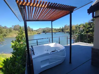 a bath tub on a deck with a view of a river at Kristal Luxury - Guatapé in El Peñol