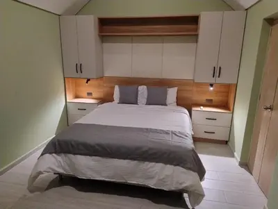 a bedroom with a large bed with white cabinets at Kristal Luxury - Guatapé in El Peñol