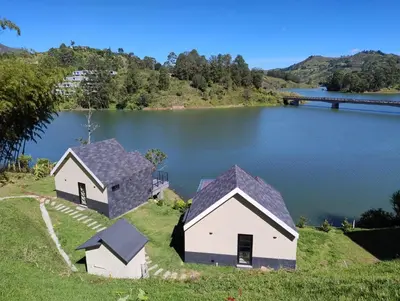 two houses on a hill next to a lake at Kristal Luxury - Guatapé in El Peñol