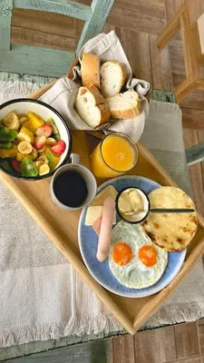 a tray of breakfast food with eggs and bread at Escápate Sonata in Chinchiná