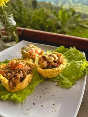 a white plate with food on top of lettuce at Escápate Sonata in Chinchiná