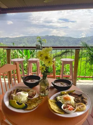 a table with two plates of breakfast food on it at Escápate Sonata in Chinchiná