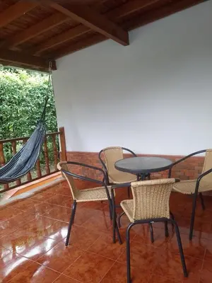 a patio with chairs and a table and hammock at Relax West Finca Hotel in Santa Fe de Antioquia