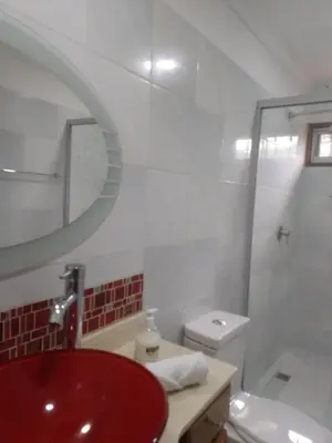 a bathroom with a red sink and a toilet at Relax West Finca Hotel in Santa Fe de Antioquia