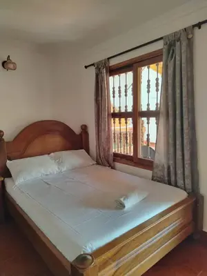 a bed with a wooden headboard and a window at Relax West Finca Hotel in Santa Fe de Antioquia