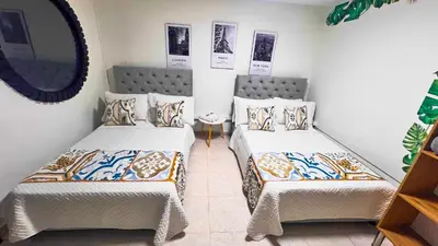 two beds in a room with a mirror at Casa La Morada in Medellín