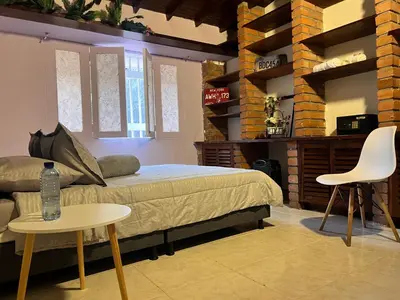 a bedroom with a bed and a table and chairs at Casa La Morada in Medellín