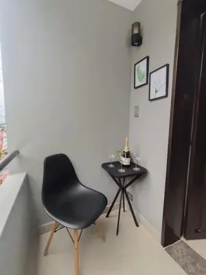 a black chair and a table with a bottle of wine at Loft Belén WiFi900Mb Av 33 Cr 70 l Balcón Vista in Medellín