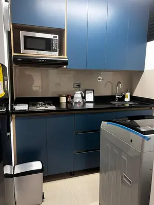 a kitchen with blue cabinets and a microwave at Loft Belén WiFi900Mb Av 33 Cr 70 l Balcón Vista in Medellín