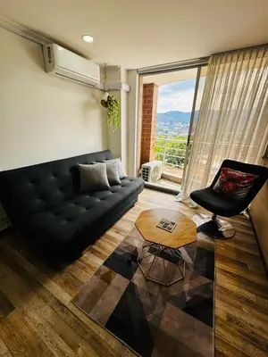 a living room with a black couch and a chair at Best location in El Poblado y Provenza in Medellín