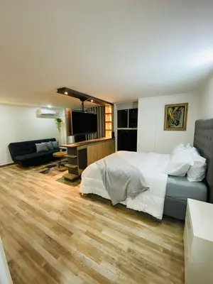 a bedroom with a bed and a living room at Best location in El Poblado y Provenza in Medellín
