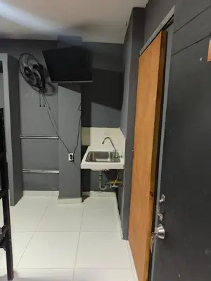 a bathroom with a sink and a door with a fan at Dulce Hogar Aparta Hotel in Medellín