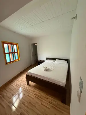 a bedroom with a bed in a white room at Hostería El Paraíso in Jardin