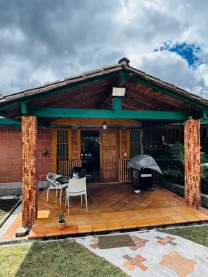 a house with a deck with a grill at Magical farmhouse near Arví Park in Mazo