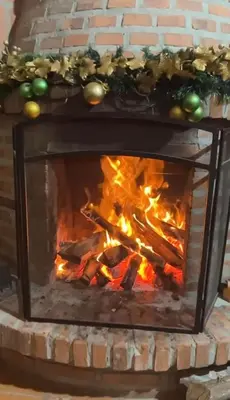 a brick fireplace with a fire in it at Magical farmhouse near Arví Park in Mazo