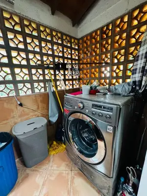 a washing machine in a room with a wooden wall at Magical farmhouse near Arví Park in Mazo