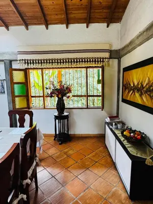 a dining room with a table and a vase of flowers at Magical farmhouse near Arví Park in Mazo