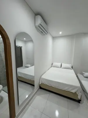 a small bedroom with two beds and a mirror at Habitaciones en Doradal 202 in Doradal