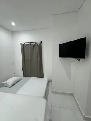 a room with two beds and a flat screen tv at Habitaciones en Doradal 202 in Doradal