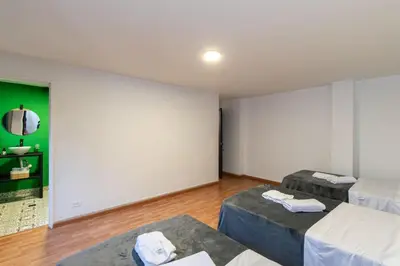 a room with two beds and a green wall at P202 4BR Poblado Apartment at Poblado Provenza in Medellín