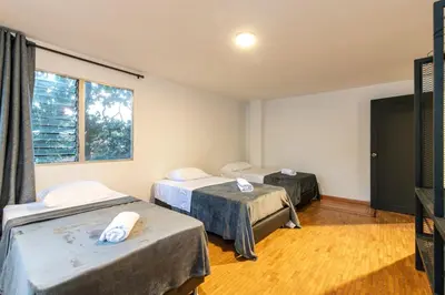 a room with three beds and a window at P202 4BR Poblado Apartment at Poblado Provenza in Medellín