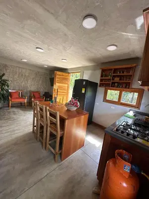 a kitchen with a table and a refrigerator and a counter at Finca El Encanto in Jericó