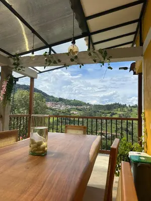 a wooden table on a balcony with a view at Finca El Encanto in Jericó