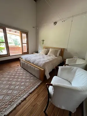 a bedroom with a bed and a couch and a chair at Espectacular villa en llanogrande in Estación El Salto