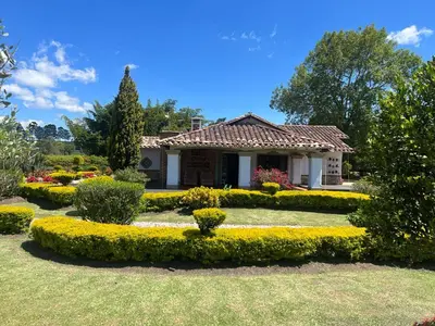 a small house with a garden in front of it at Espectacular villa en llanogrande in Estación El Salto