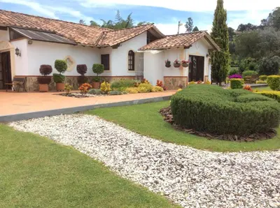 a house with a garden and a gravel driveway at Espectacular villa en llanogrande in Estación El Salto