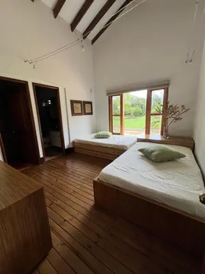 a large room with two beds and a window at Espectacular villa en llanogrande in Estación El Salto
