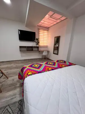 a bedroom with a large bed and a flat screen tv at Meraki Urban Lofts in Quibdó
