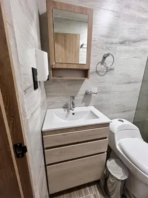 a bathroom with a sink and a toilet and a mirror at Meraki Urban Lofts in Quibdó