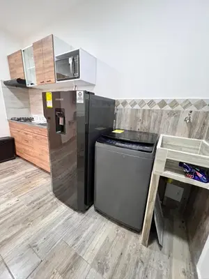 a kitchen with a black refrigerator and a counter at Meraki Urban Lofts in Quibdó